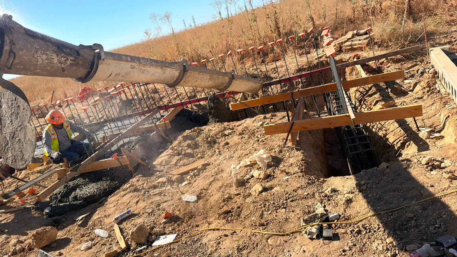 Concrete running down the mixer's extension chutes into a rebar footing